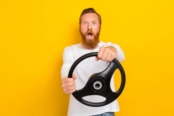 Photo of puzzled confused person hand hold wheel stare speechless open mouth isolated on yellow color background.