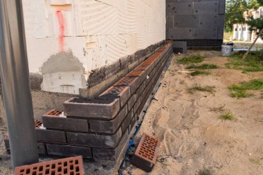 Evin etrafında tuğlalar var.