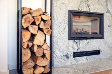 Oturma odasında şömine, odunlar için yer var.