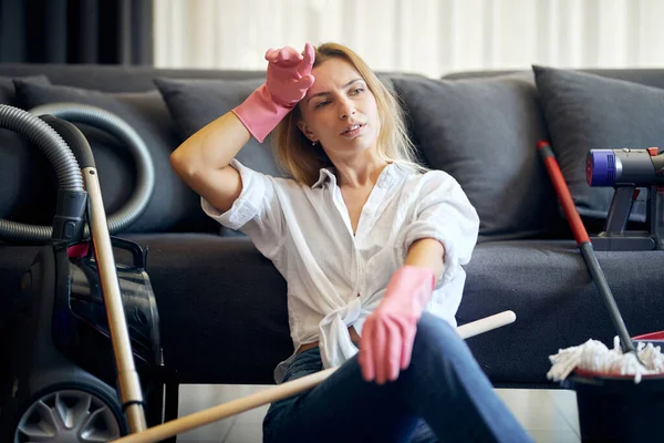 Temizlikçi kadın kanepenin yanında oturduktan sonra çok yorgun düştü.