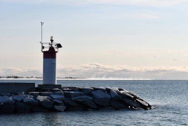 Frozen ice covered rocks on light house pier 