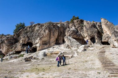 Afyonkarahisar, Türkiye - 26 Eylül 2021: İnsanlar Phrygian Vadisi 'ndeki antik mağaraları ziyaret ediyorlar. Phrygian Vadisi, binlerce yıl öncesine dayanan mağaraları ve taş evleri olan tarihi bir bölgedir..