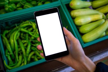 Cep telefonu kullanan bir kadın, alışverişte boş beyaz ekranlı cep telefonu tutan bir kadının görüntüsü..