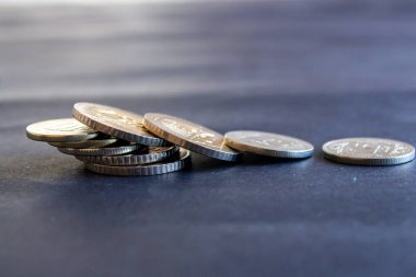 Siyah zemin üzerinde Türk lirası sikkeleri, metal para sikkelerine yakın plan.