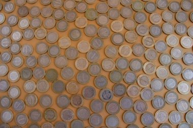 Türk Lirası sikkeleri, renkli arkaplandaki birçok madeni paranın üst görünümü.