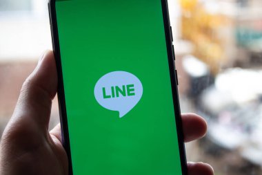 Satır uygulama simgesi ile el ele tutuşan telefon 