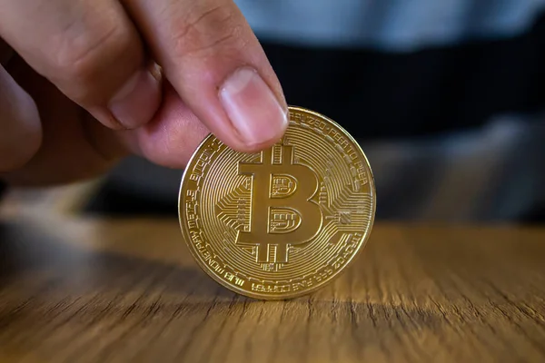 Altın Bitcoin 'i tutan adamın eli. Kripto para birimi yatırım konsepti fotoğrafı.