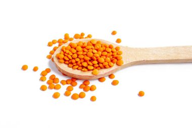 Beyaz arka planda izole edilmiş bir kaşıkta kırmızı mercimek. Üst manzara, düz uzanma.