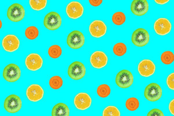 Fruits slices seamless pattern, top view of kiwi, lemon and carrot slices isolated on blue background.