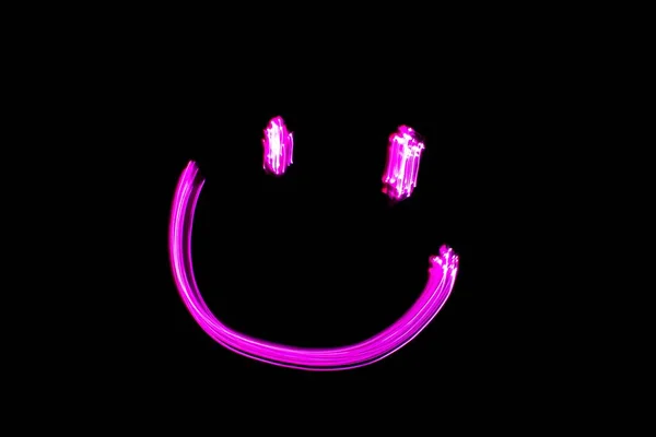 Neon Smiling Face Light Painting Pink Smiling Face Black Background — стоковое фото