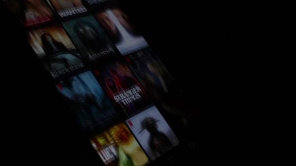 Afynokarahisar トルコ 2022年1月4日 Netflixアプリ上で男の手スワイプ携帯電話の画面 スマートフォンでNetflixモバイルアプリを使用 男は良い映画やシリーズを探しています — ストック動画