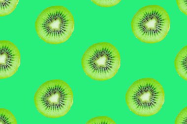 Kivi dilimleri deseni, yeşil arka planda izole edilmiş kivi dilimlerinin üst görüntüsü. Tropikal meyve konsepti fikri fotoğrafı.