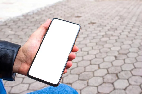 Мужчина Держит Мобильный Телефон Чистым Белым Экраном Сидя Парке Изображение — стоковое фото