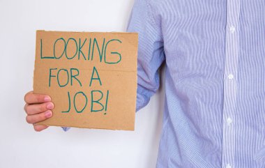 İşsiz bir adam bir iş arayan bir yazı tahtasıyla tabela tutuyor. İşini kaybetme ve yeni bir iş arama kavramı. Finansal sorunları var..