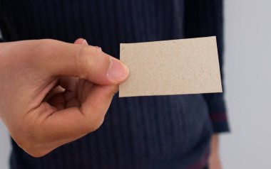 Elinde boş bir kartvizit tutan bir işadamı. Sahte kartvizit şablonu. Uzayı metin için kopyala. Yakın çekim..