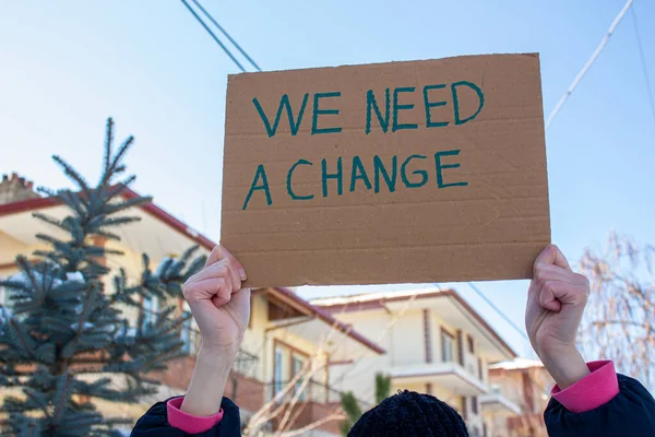 Mano Sosteniendo Caja Cartón Con Necesitamos Cambio Texto Mujer Protestando —  Fotos de Stock