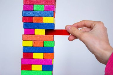 Tahta kule oyunu oynamak, el ele tutuşmak beyaz arka planda izole edilmiş tahta oyun bloğu.