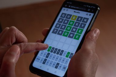 Afyonkarahisar, Türkiye - 24 Şubat 2022: Telefonunda Wordle Game oynayan kadın. Son zamanların popüler kelime oyunu Wordle 'dır.