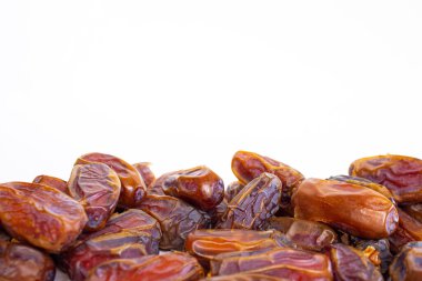 Beyaz arkaplanda izole edilmiş kurutulmuş tarihlerin yakın plan fotoğrafı.