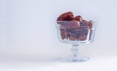 Kasede kurumuş hurmalar, beyaz arka planda izole edilmiş. Mesaj için yer var. Müslümanlar için geleneksel iftar yiyeceği.