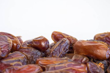 Beyaz arkaplanda izole edilmiş kurutulmuş tarihlerin yakın plan fotoğrafı.