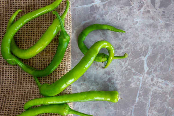 Masada olgun yeşil biberler var. Metin için yeri olan biberlerin en üstteki görünüm fotoğrafı.