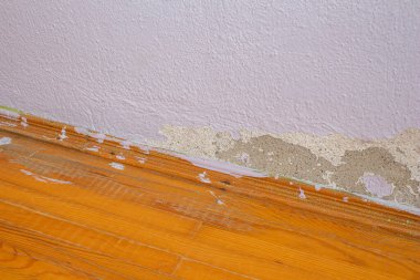 Eski hasarlı beton duvar ve parke zemin. Eski yıpranmış duvarlı terk edilmiş bir ev..