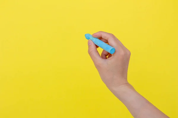 Hand Holding Chalk Isolated Yellow Background Woman Writing Something Blue — Stock Photo, Image