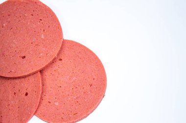 Beyaz arka planda izole edilmiş bir salam dilimi. Ham salamın fotokopi alanı ile en iyi görünüm fotoğrafı.