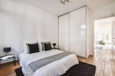 Siyah yastıklı yumuşak yataklı lüks bir yatak odası.