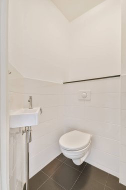 Duvara asılmış tuvaleti olan çekici bir tuvalet.