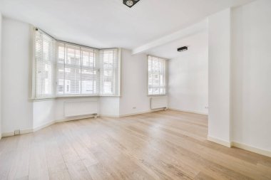 Geniş pencereli, ferah, parlak bir oda.