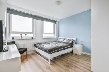 Gri yatak örtüsü olan çekici bir yatak odası.