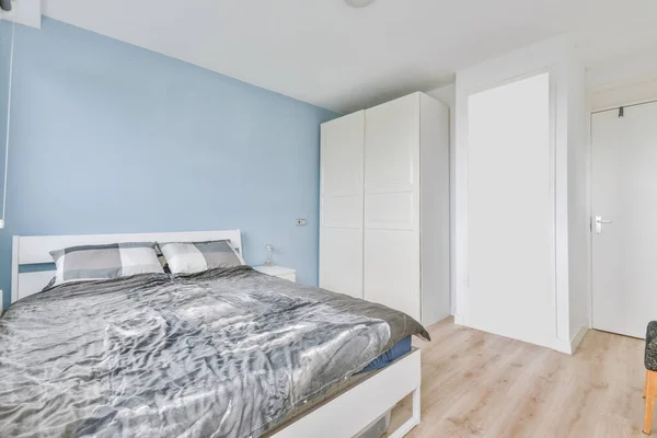 Привлекательная спальня с обычным серым покрывалом — стоковое фото