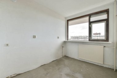 Büyük pencereli ve parke zeminli hoş bir oda.