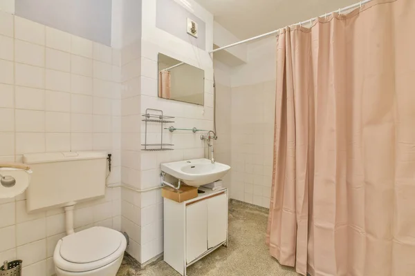 Łazienka z różową zasłoną oddzielającą prysznic — Zdjęcie stockowe