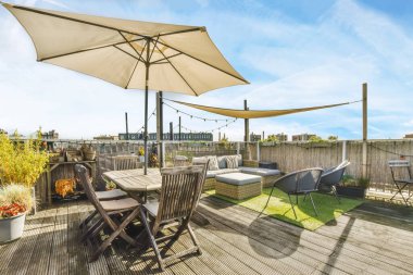 Bahçe şemsiyeli lüks ve şık bir avlu.