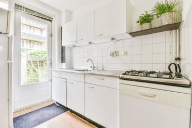 Mutfakta beyaz mutfak ünitesi var.