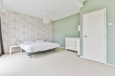 Yuvarlak tasarımlı avizesi olan büyük bir uyku alanı.