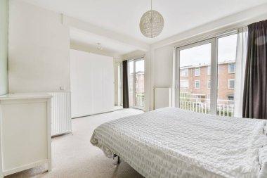 Yuvarlak tasarımlı avizesi olan büyük bir uyku alanı.