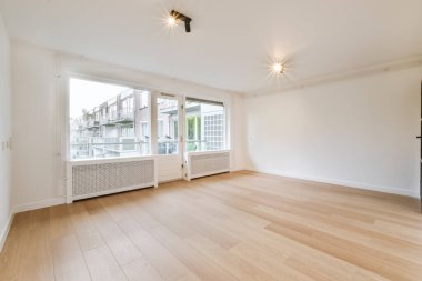 Büyük pencereli ve parke zeminli oda