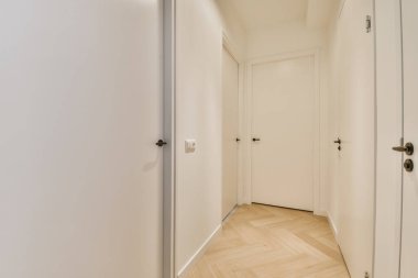 Bir sürü kapısı olan uzun boş bir koridor.