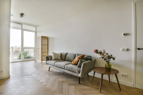 Szürke kanapé párnákkal a nappaliban — Stock Fotó