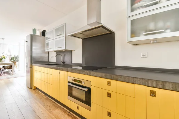 Schöne Küche mit gelber Küchenzeile und Hängeschränken — Stockfoto