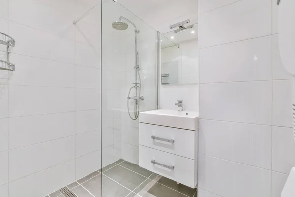 Ванная комната с небольшой раковиной и современным душем — стоковое фото