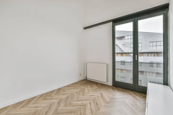 Маленькая уютная комната с большими двустворчатыми окнами — стоковое фото