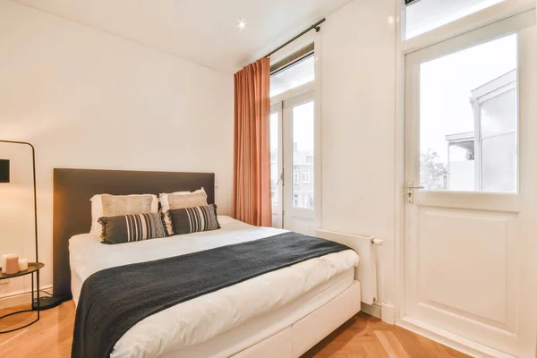 Элегантная спальня с двуспальной мягкой кроватью — стоковое фото