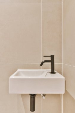 Minimalist tarzda küçük lavabolu şık bir banyo.