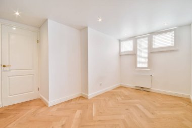 Küçük pencereli rahat bir oda.