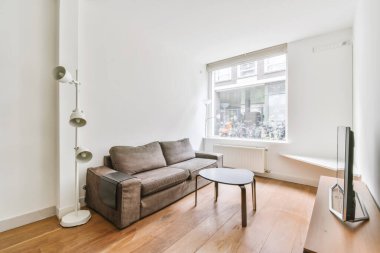 Yuvarlak kahve masası ve televizyonu olan şık bir oturma odası.